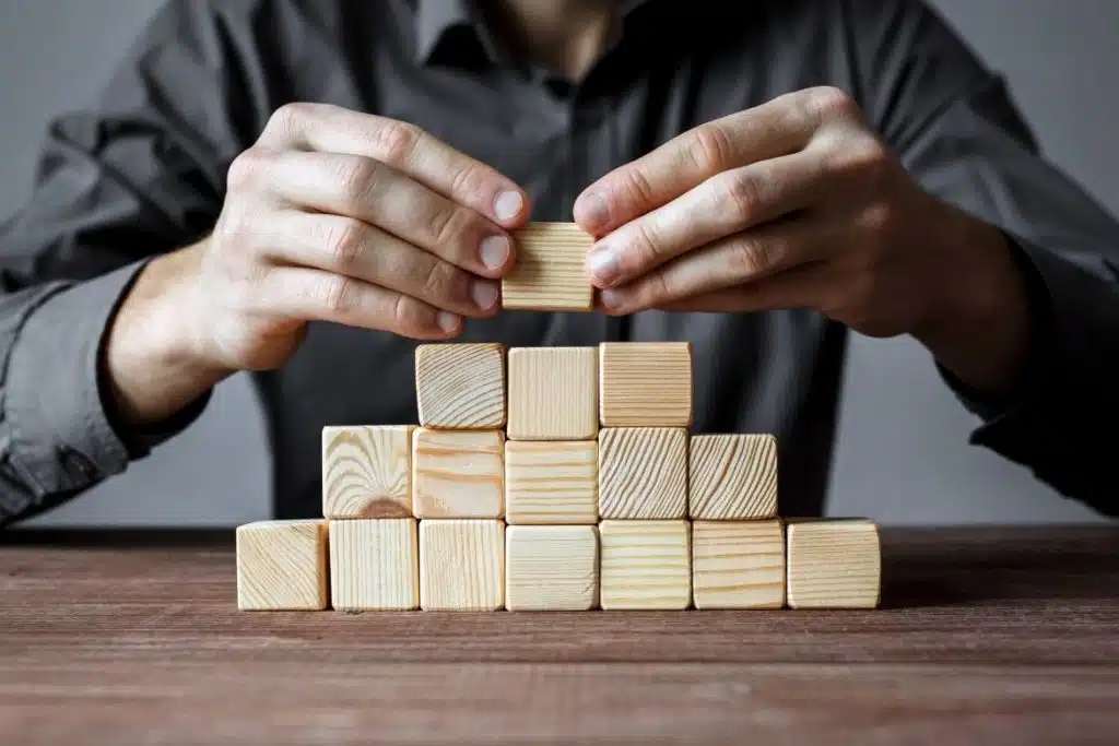Houten blokken die stap voor stap worden opgebouwd als metafoor voor een logische presentatie-opbouw.