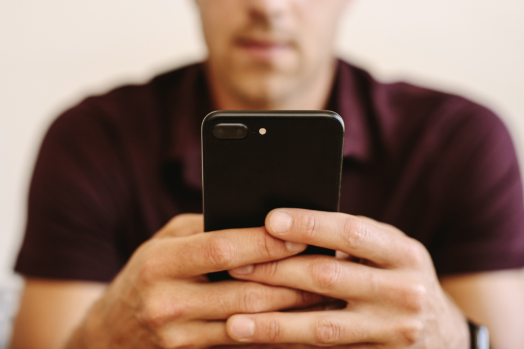 Man kijkt gespannen naar zijn telefoon voordat hij moet bellen